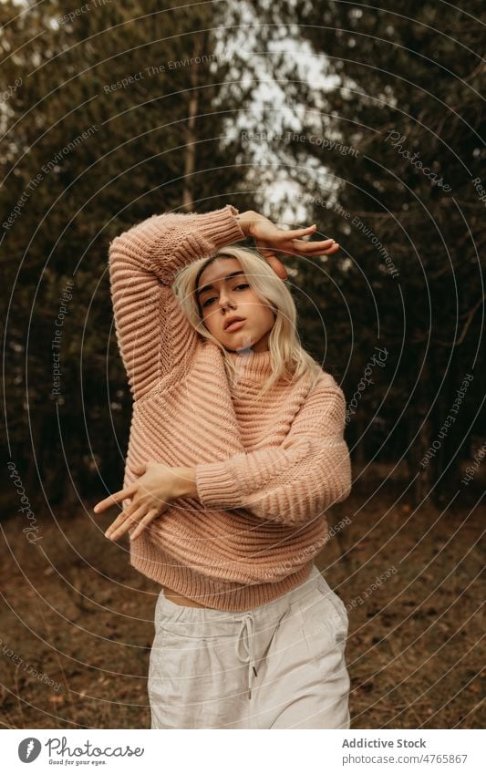 Blond woman enjoying dance in woods freedom nature dream forest tree portrait serene spread arms style calm woodland sweater harmony fair hair mood dreamy lady