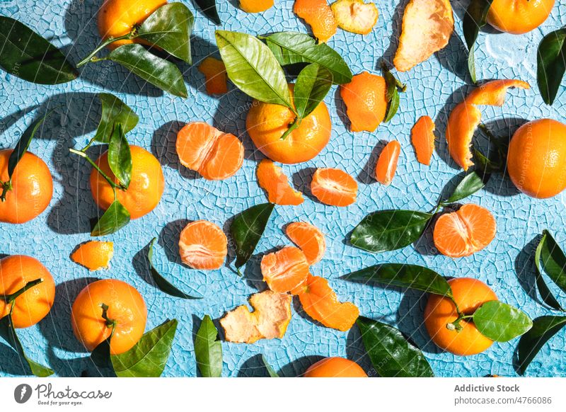 Tangerines and leaves with peel on cracked background tangerine leaf exotic fruit slice citrus ripe tropical composition colorful vitamin fresh bright mandarin