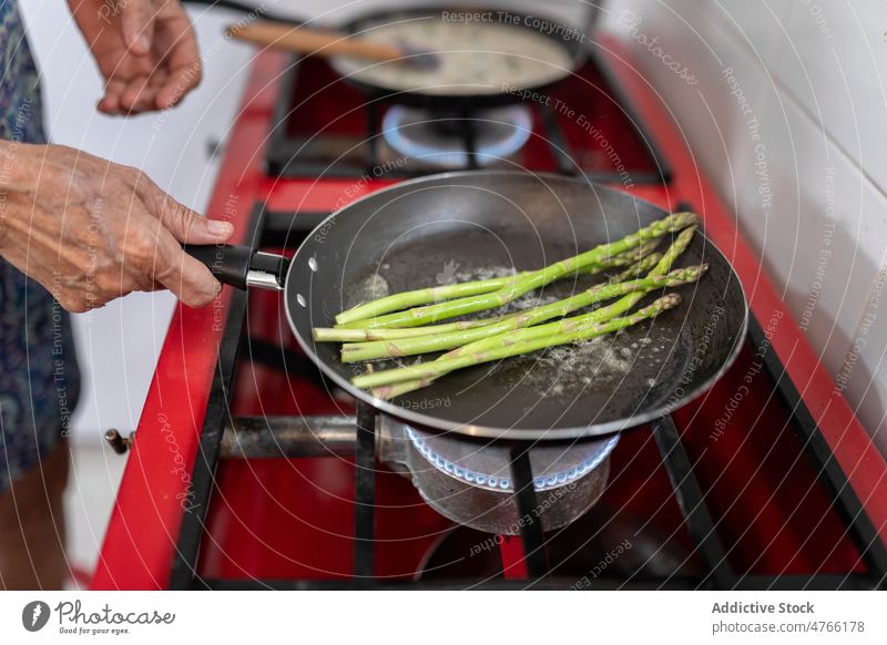 Unrecognizable chef frying asparagus in kitchen cook culinary food cuisine recipe stove fresh prepare mexican process focus gastronomy work light lifestyle