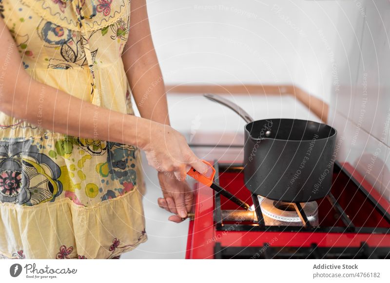 Unrecognizable woman lighting gas stove lighter kitchen burn pan culinary kitchenware appliance Mexican food mexican hispanic ethnic mixed race lady recipe