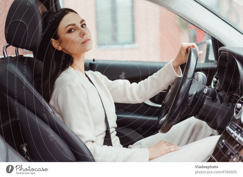 Photo of happy young woman sitting inside her new car. Concept for car rental female vehicle people owner transportation caucasian lifestyle automobile customer