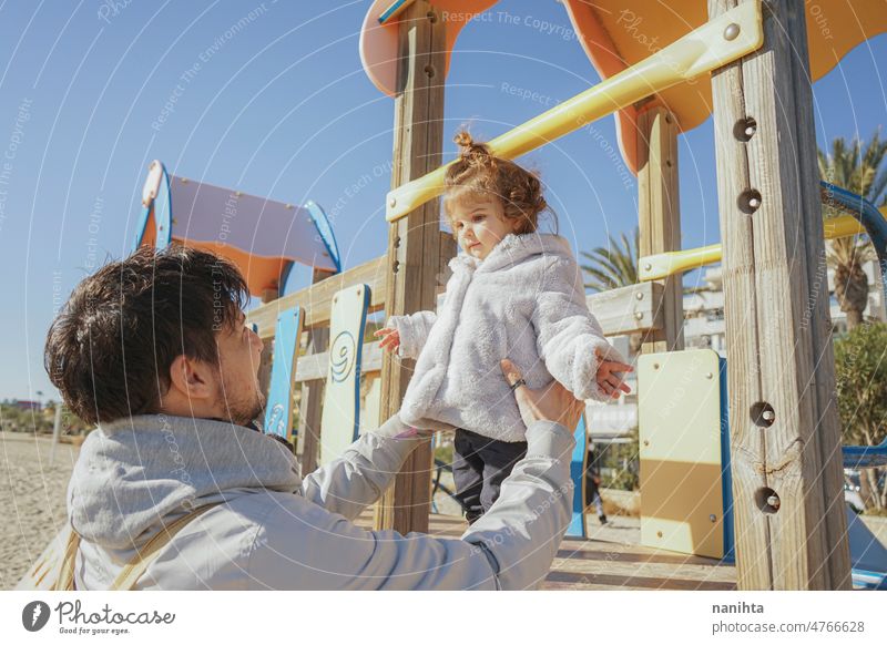 Father and daughter spending time together at the playground in a sunny day single dady family toddler holidays winter life candid everyday routine park