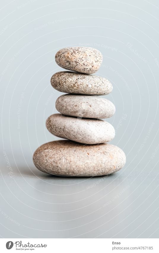 Stones stacked in pyramid, balance, stability, zen, meditation, body mind and soul harmony concept stones stack minimal minimalism relaxation pebble rock spa