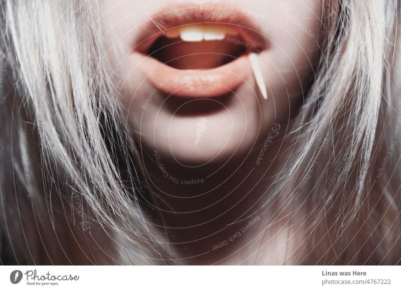 A closeup of a beautiful blonde girl. Just this time only white teeth, red lips, and a lustful mood is in this one. And a toothpick in her mouth. A method to quit smoking.