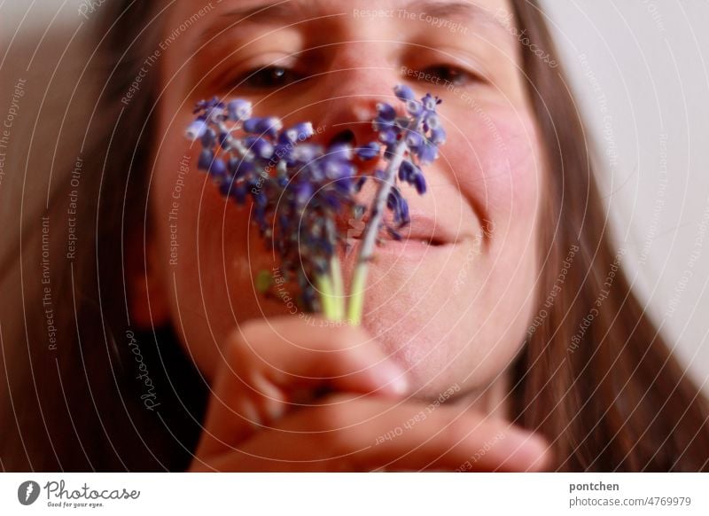 A woman holds a small bouquet of flowers she picked herself and sniffs it. Naturalness, wellness, joy. Smell good Woman meadow flowers purple naturally