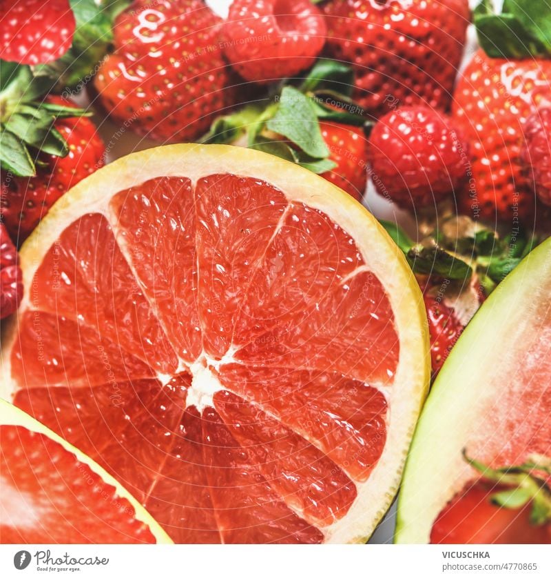 Close up of red grapefruit half and strawberries. Fruits background close up fruity juicy healthy refreshing summer fruits delicious snack vitamins top view