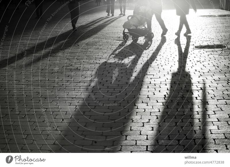 You can't run away from everyday shadows - but you can turn your back on them now and then! city stroll Shadow people shop Evening Evening sun B/W Baby carriage