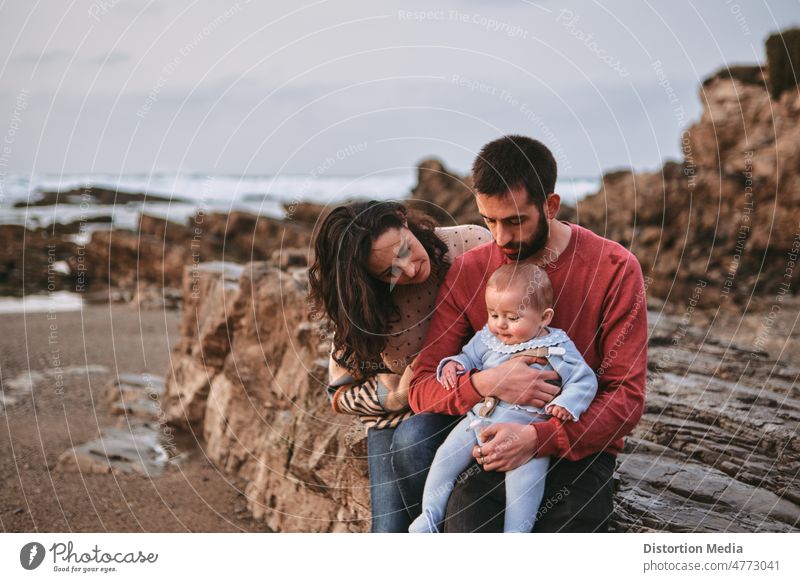 Portrait of a traditional family on a beach where father and mother hug their baby with Copyspace nice positivity wellness baptism christening marriage
