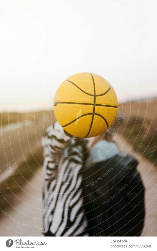 young couple secretly kissing behind a yellow basketball love close up two people countryside hiden embraced embracing journey weekend man woman adult nature
