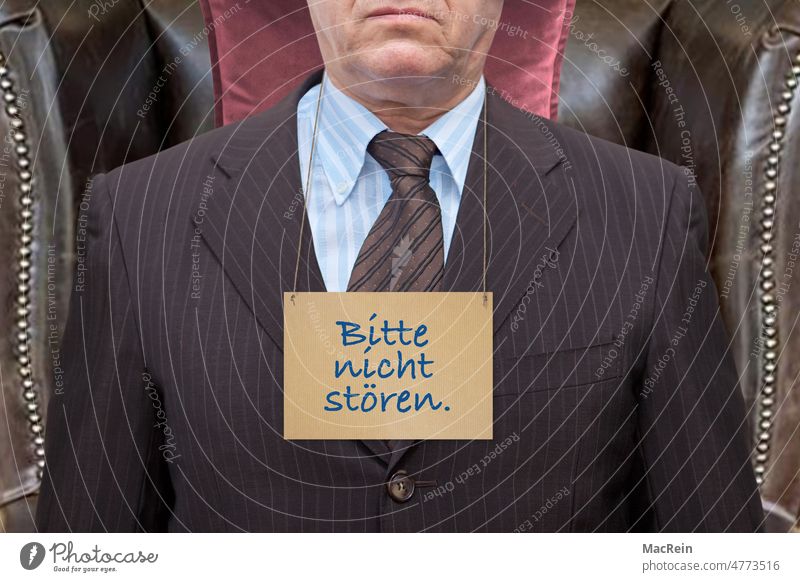 "Do not disturb" manager with a sign around his neck Please do not disturb Signage Sleep Politician Armchair ear chair Man Suit Text