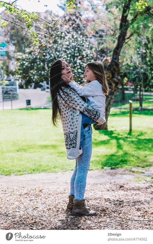 Little cute child baby hugging mom, embrace with happy pretty woman in green park. kiss parent together daughter happiness joy love mother motherhood people