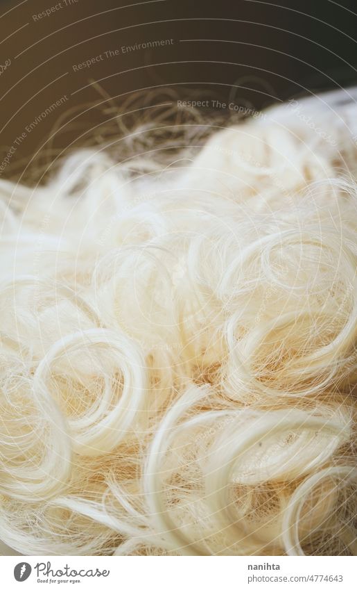 Textured image of a close up of the platinum blond hair of an artificial wig texture dyed colored background soft smooth fantasy haistyle hairdresser blonde
