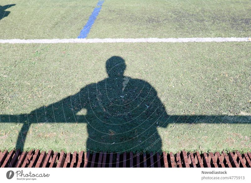 Shadow of an adult reflected on green grass Reflection person outdoors outside Grass Image daylight lifestyle Abstract sports field