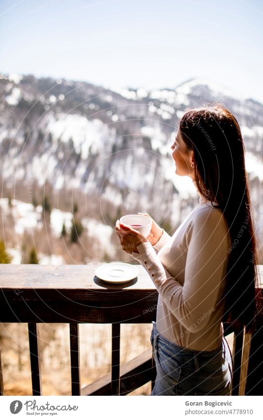 Young woman with cup of hot tea in winter window morning breakfast lifestyle young relax people home smile beautiful female dreaming attractive drink cute