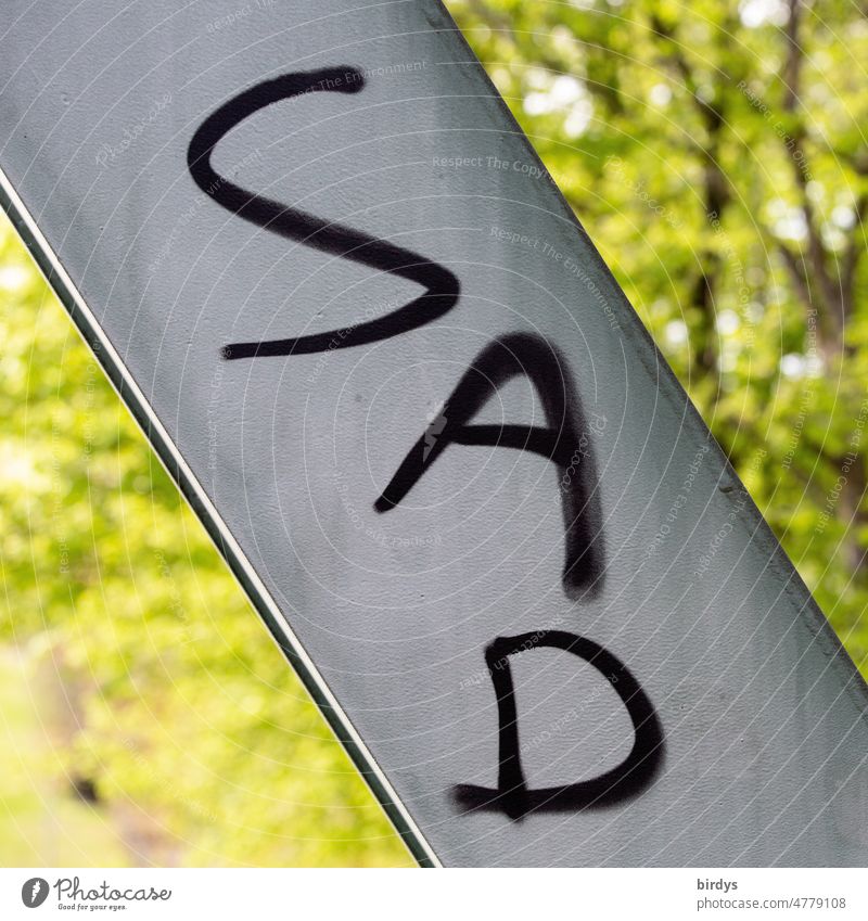 " Sad ", " sad " in English writing. Graffiti on a metal strut. Format filling, weak depth of field Sadness sorrow sorrowful Concern Pain depression War
