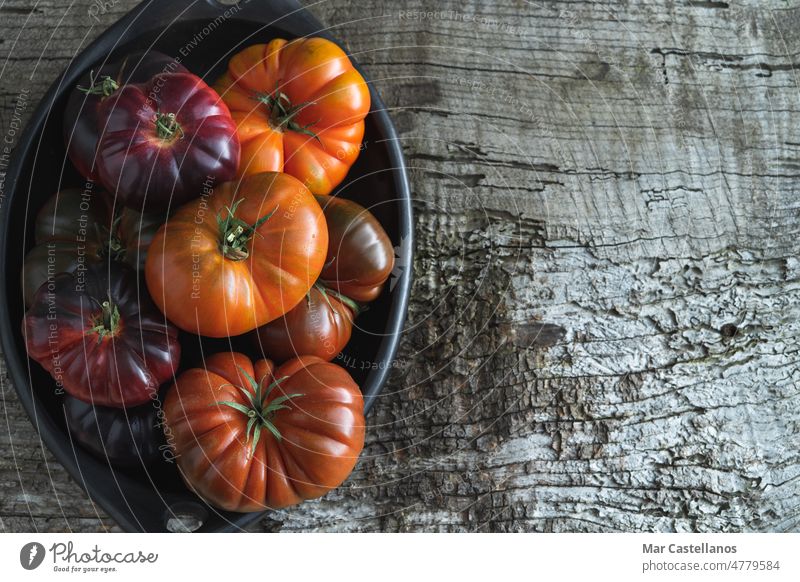 Tray with raf tomatoes and blue sea on old wood background. Copy space. plate tray species vegetable fresh purple ripe copy top view white salad vitamins