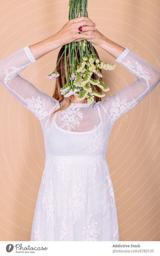 Anonymous bride covering eyes with flowers woman white dress wedding style occasion bouquet floral cover eyes hide event elegant plant present smell fragrant