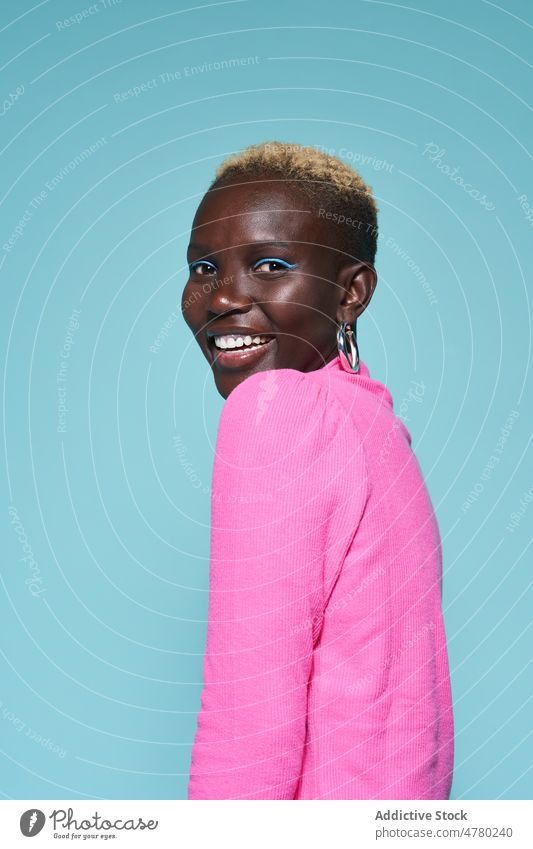 Portrait of a smiling woman style short hair dyed hair feminine trendy fashion hairstyle appearance female african studio smile positive outfit lady garment