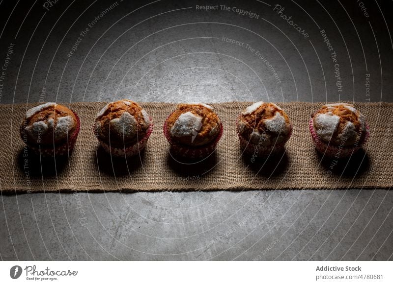 Row of delicious baked muffins sweet dessert pastry homemade row confection culinary treat neat arrange tasty still life yummy food palatable textile kitchen