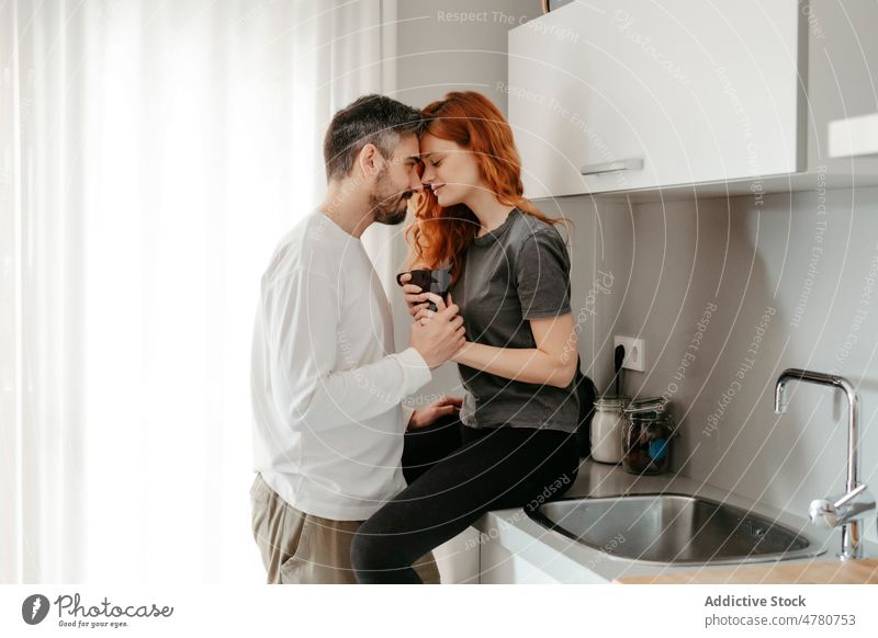 Couple caressing on kitchen counter couple redhead relationship love bonding cuddle red hair romantic affection ginger fondness long hair coffee together home