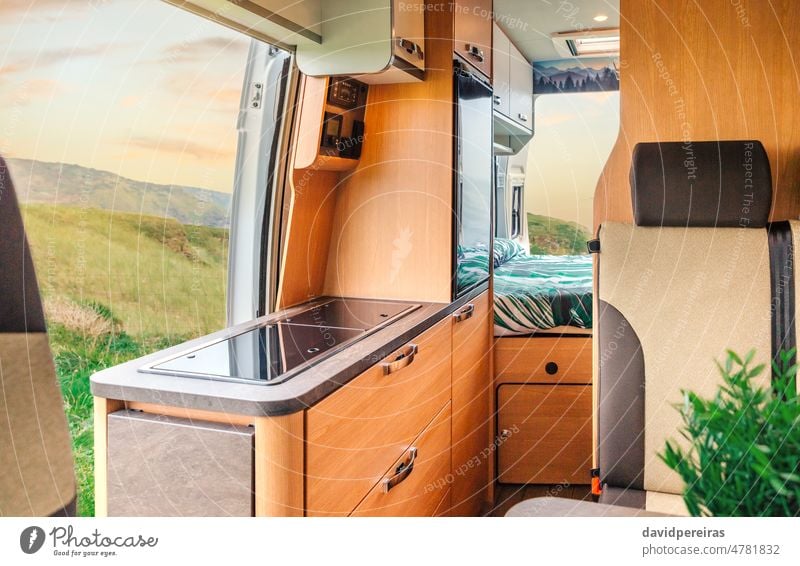 Interior of a camper van with kitchen and bed interior indoor drawer home seat nobody clean vacation campervan vehicle camping cozy kitchen counter fridge car
