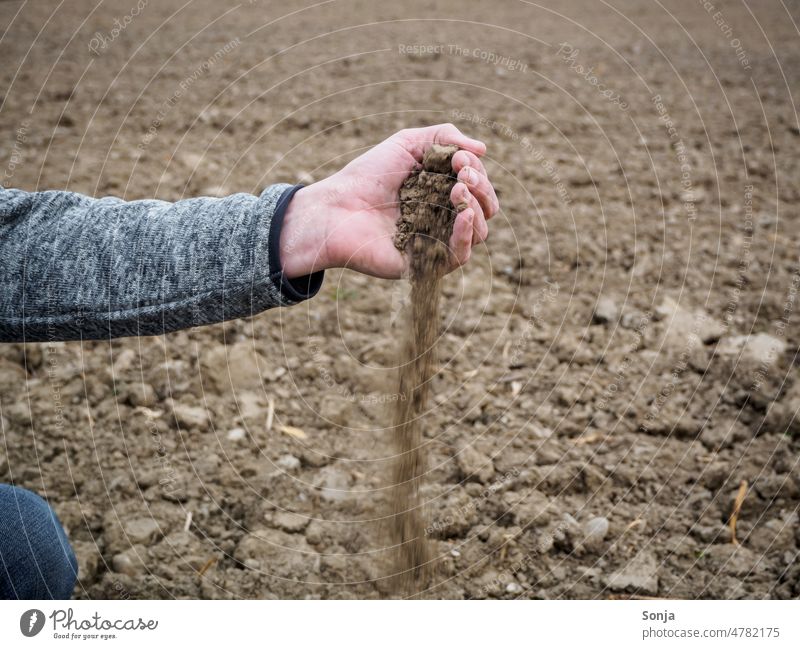 Ein Bauer prüft die Erde auf Trockenheit Dürre Klima Mann Feld natur landschaft umwelt teilabschnitt acker trocken herbst Frühling Hand braun