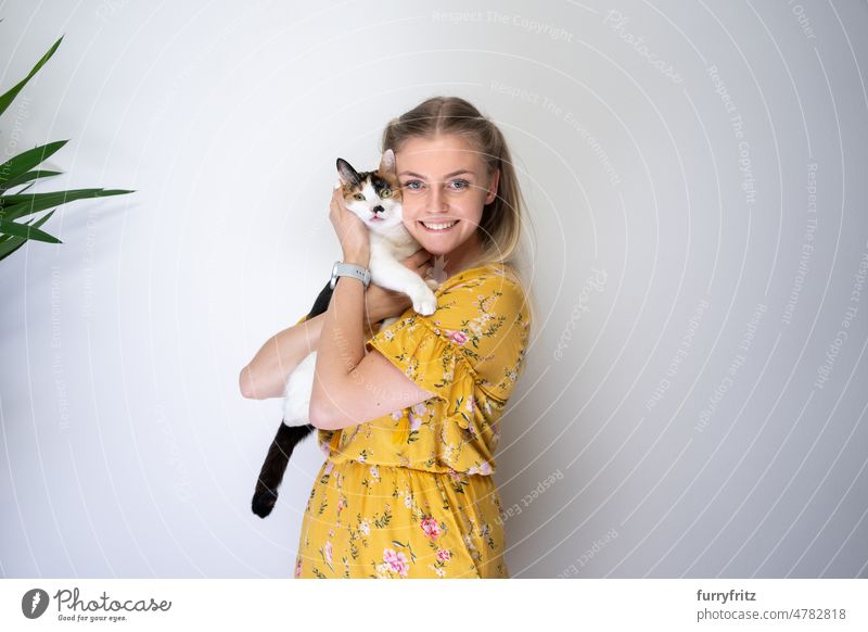 young blond woman embracing her cat with copy space kitty one animal pet owner young woman female person caucasian girl blond hair dress floral yellow long hair