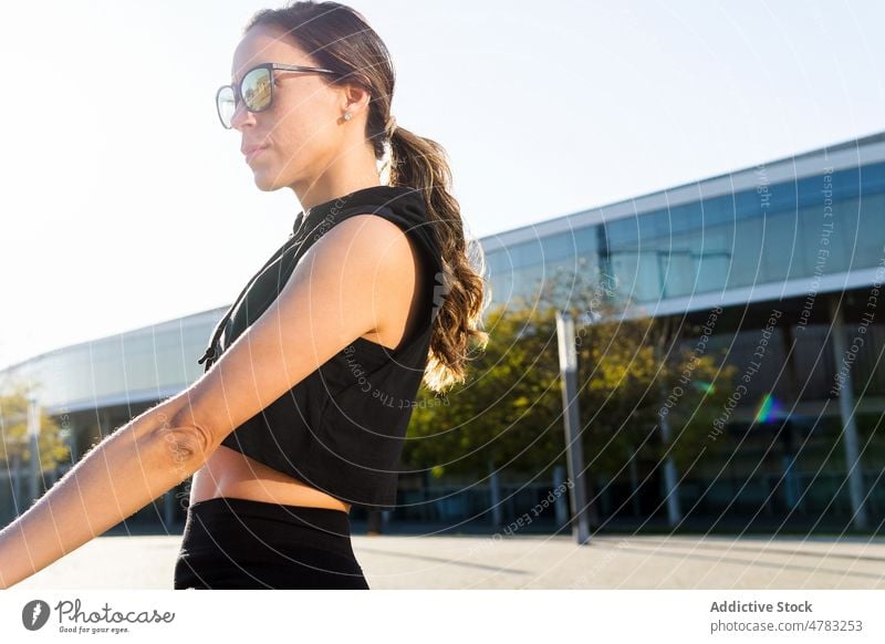 Sportswoman in sunglasses standing on the street sportswoman training break workout adjust athlete pause healthy lifestyle activewear sporty wellbeing city