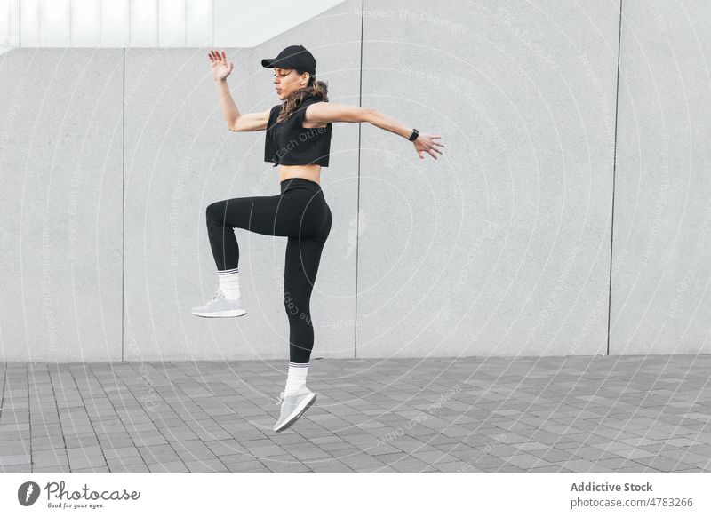 Fit sportswoman jumping in city training workout athlete street exercise active sporty female practice healthy lifestyle wellbeing activewear sportswear