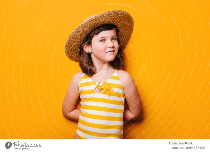 Cheerful girl in straw hat kid swimsuit summer leisure journey recreation style appearance trendy childhood design positive light cute studio modern adorable