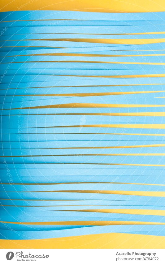 Minimalist cut paper stips background in blue and yellow colors. strips minimalism still life abstract lines stationary cutter knife texture stripes simplicity