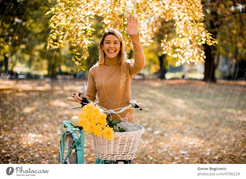 Happy active woman riding bicycle in autumn park bike biking casual caucasian enjoy enjoyment fall female foliage forest happy healthy leaves leisure lifestyle