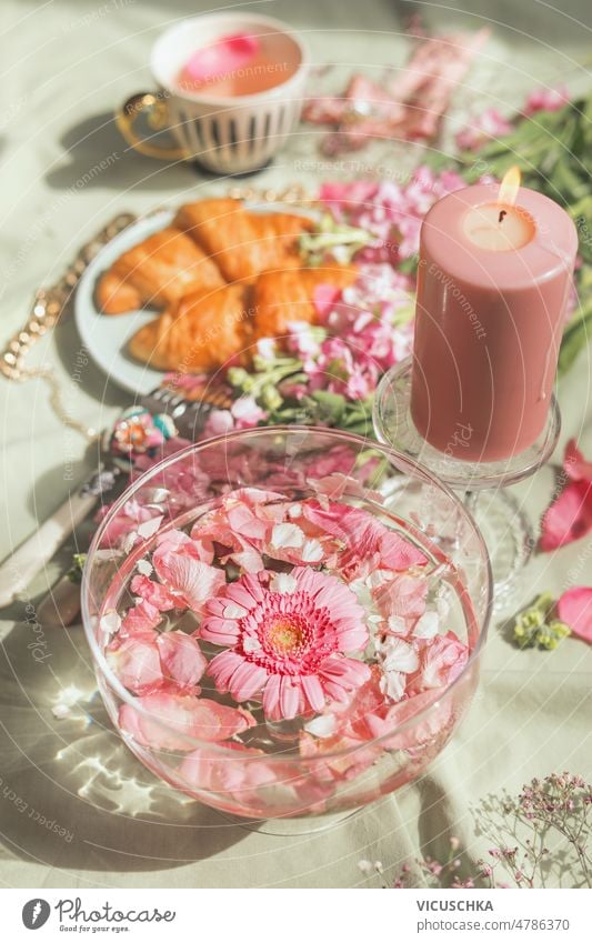 Aesthetic breakfast with glass water bowl and pink flowers with candle, croissants and tea cup aesthetic elegant food drink fancy drink top view champagne glass
