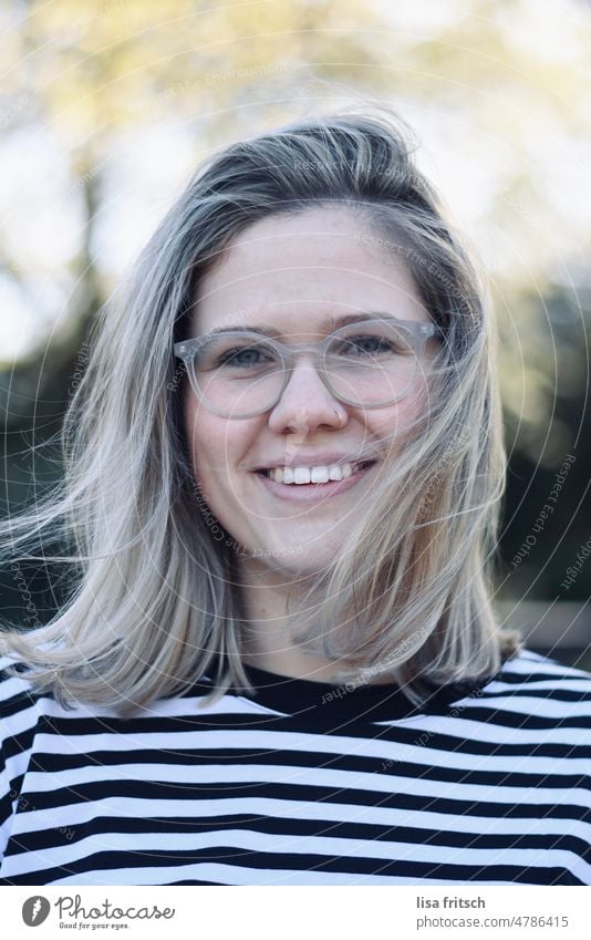 WOMAN - BLONDE - WINDY - GLASSES Woman 25-29 years blonde hair Adults Colour photo Exterior shot Young woman 20s Eyeglasses Nasal piercing windy pretty Smiling