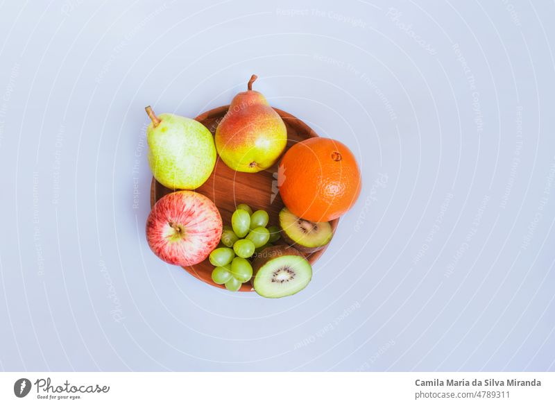 Assortment of fruits on a wooden plate and white background. agriculture appetizer apple assorted assortment citrus delicious dessert diet different eat food