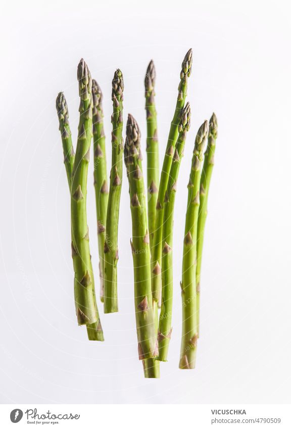 Green asparagus flying at white background. Levitation food green levitation concept seasonal spring vegetable front view bunch flying food fresh