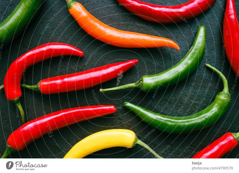 Colorful chili peppers on a brown wood background Chili Husk variegated Tangy hot Colour photo Fiery Vegetable Nutrition Food Spicy Vegetarian diet