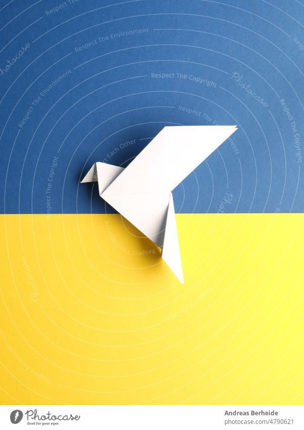 Peace symbol with an origami dove on blue and yellow paper world peace freedom global pigeon love trust hope color Ukraine flag transformation concept together