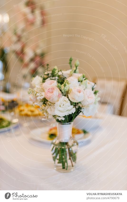 A delicate bridal bouquet of the bride stands in a glass vase on a festive banquet table event luxury wedding arrangement beauty celebration decoration flower