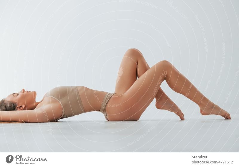 Beautiful slim body type. Woman in underwear is posing in the studio woman skin legs lingerie back female style fashion indoors white caucasian european