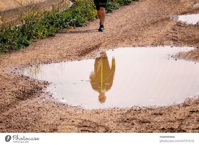 Reflection of a man in a puddle Sports Puddle puddle mirroring Water reflection Exterior shot Man Water puddle Walking Mirror image