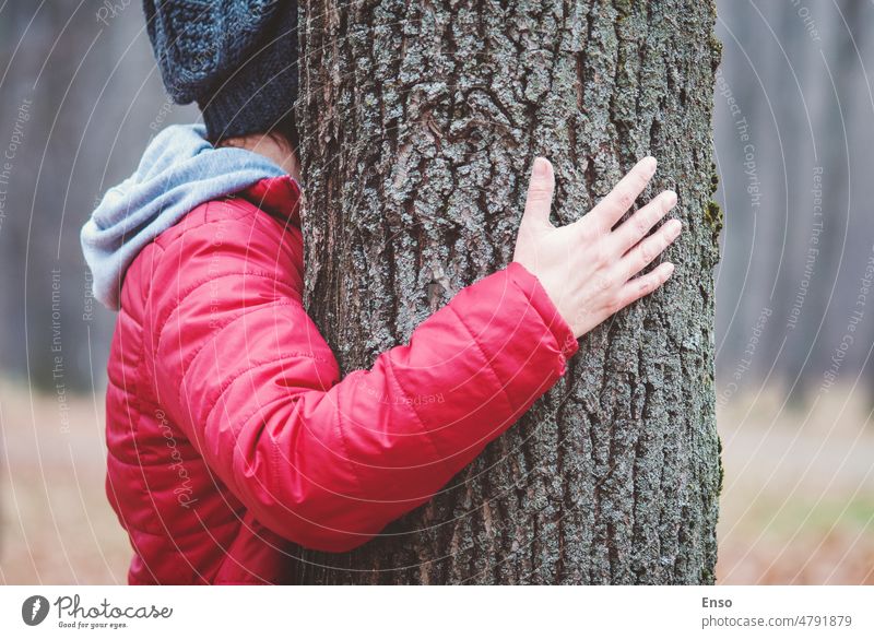 Hugging tree trunk in autumn park, woman embraces old tree outdoors, love and unity with nature hugging hands forest touch care concept protection ecology wood