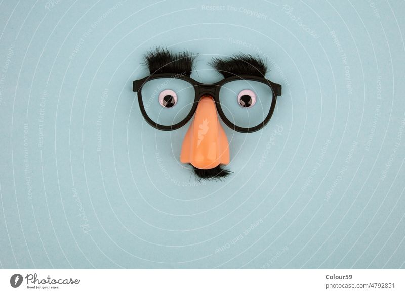 Funny mask with thick black eyebrows, glasses and big nose Mask Eyebrows Nose symbol Eyeglasses Face eyes Home-made light blue background creation creatively
