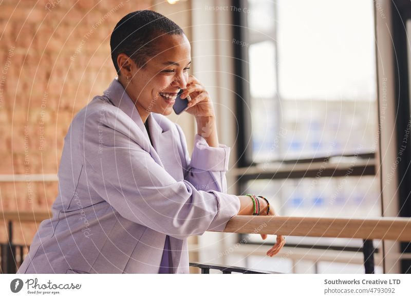 Portrait of cheerful multiracial LGBTQ mid adult woman using smartphone having conversation and smiling portrait lgbtq smile lean railing happy business