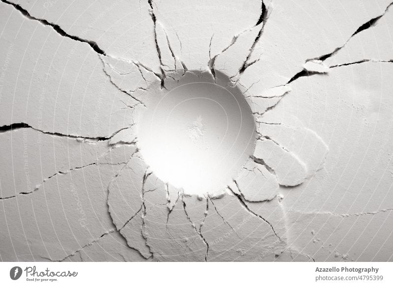 White powder surface with cracks and a round crater. Crater in black and white. abstract art asteroid backdrop background chaotic circle concept cracked