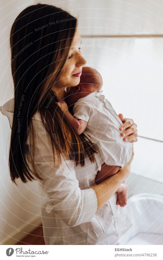 Young mother holding newborn baby Mother child care family woman childhood small parent person cute infant little love motherhood happiness female caucasian mom