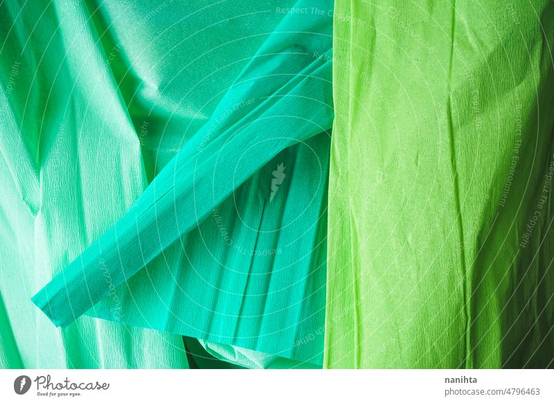 Green textured image of crepe paper in green tones lime background tonal duotone shape abstract wallpaper simple backdrop light shadow bio eco recycled soft