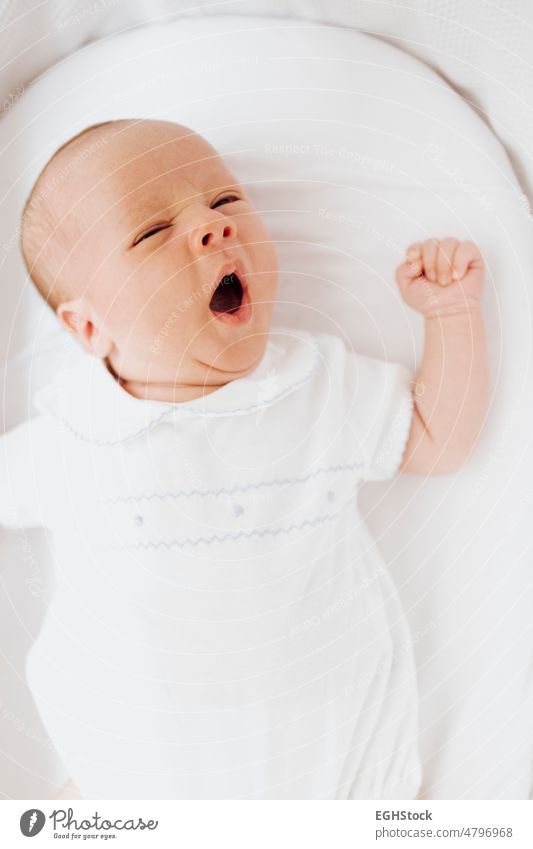 Close up newborn baby boy yawning in the crib open mouth. Vertical photo. close up vertical crin eyes child person infant cute innocence childhood sleep