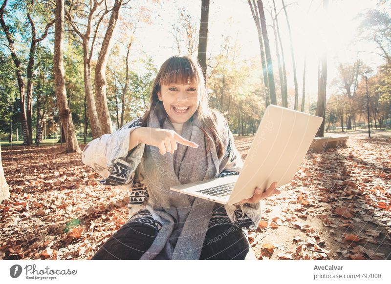 Young excited entrepreneur outdoors pointing a laptop with business concept. Young people saving money concept image. Copy space to add images and text image. Working outdoors concept.