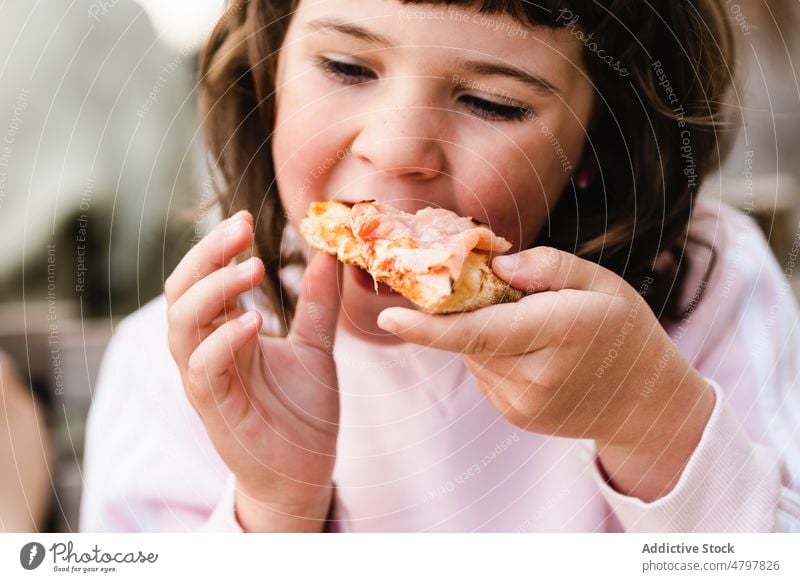 Girl eating pizza for lunch girl street restaurant bite delicious hungry daytime table sit fast food little pizzeria italian cuisine childhood nutrition
